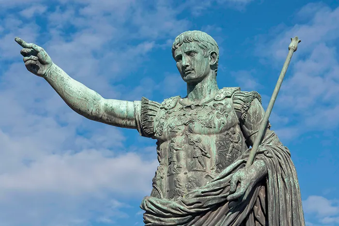Estatua de Octavio Augusto en el Foro Romano señalando con armadura y bastón bajo el cielo