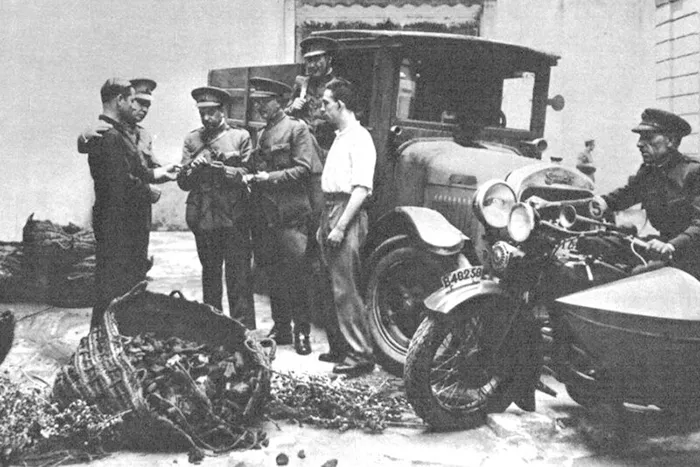 Carabineros revisan un cargamento decomisado junto a un camión y una motocicleta con sidecar durante la Guerra Civil Española.