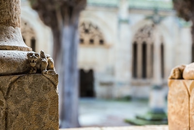 Figura grotesca acurrucada junto a una columna en el claustro de Ciudad Rodrigo.