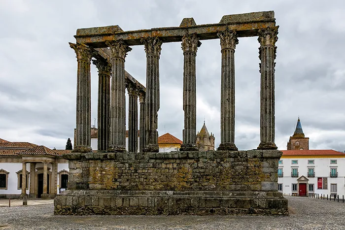 Vista frontal del templo romano de Évora en un día nublado.