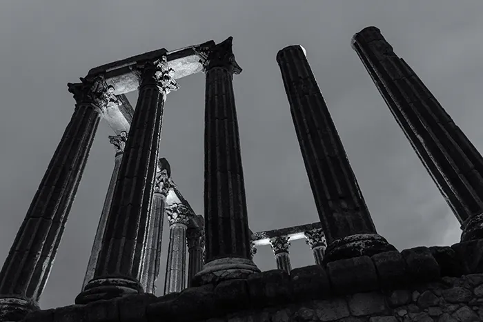 Detalle nocturno del templo romano de Évora iluminado en blanco y negro.
