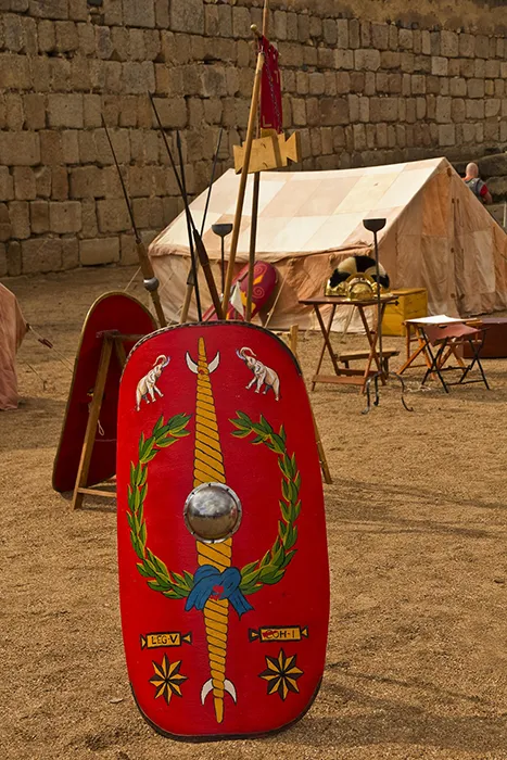 Escudo romano y equipamiento militar en una recreación histórica durante Emerita Lvdica en Mérida.