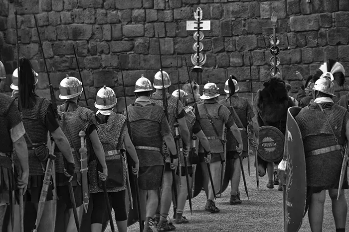 Participantes vestidos como legionarios romanos marchando en una recreación histórica durante Emerita Lvdica en Mérida.