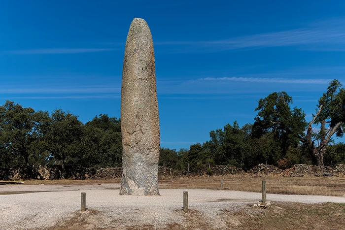Vista frontal del Menhir da Meada erguido en su base original, en un entorno natural despejado.