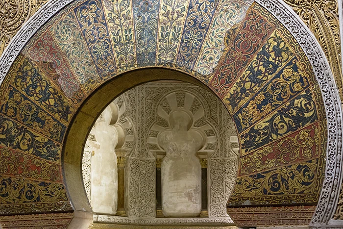 Detalle del arco del mihrab de la Mezquita Catedral de Córdoba con mosaicos bizantinos en oro, azul y rojo y decoración vegetal.