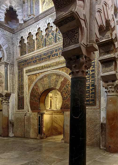 Perspectiva lateral del mihrab de la Mezquita Catedral de Córdoba con columnas y arcos entrelazados de la maqsura.