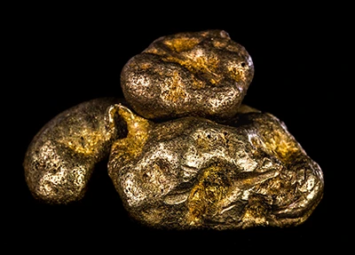 Pepitas de oro sobre fondo negro.