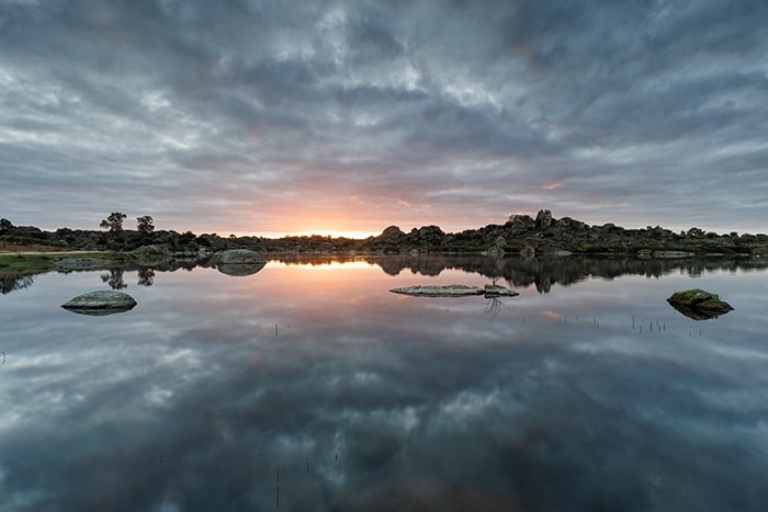 Vista natural de Los Barruecos al amanecer, con sus formaciones rocosas y charcas características.