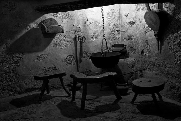 Cocina original del Convento del Palancar con utensilios antiguos de hierro y madera.