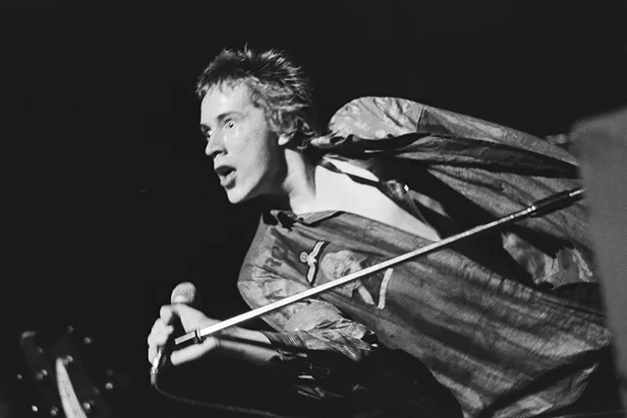 Johnny Rotten, cantante de Sex Pistols, actuando en el escenario durante un concierto punk en 1977.